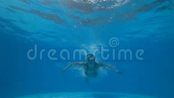 美丽的女孩睁开眼睛漂浮在清澈的蓝色游泳池里在背景气泡上视频的预览图