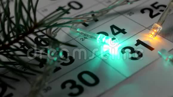 桌子上摆着的是新年12月的日历12月31日左右的新年灯在燃烧视频的预览图