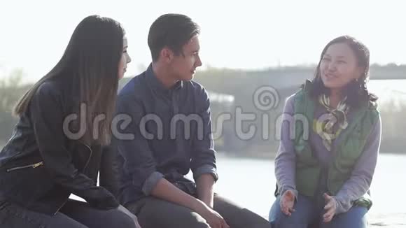 日落时分三个快乐的亚洲青少年坐在街上视频的预览图