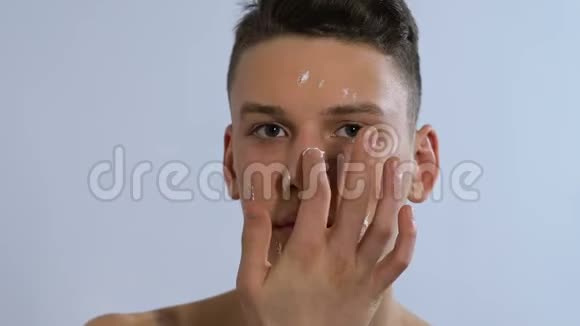 男人脸上涂抹保湿霜微笑家庭水疗护肤视频的预览图