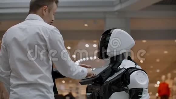 两个人一男一女与机器人交流用手按屏幕上的机器人一个机器人助手视频的预览图
