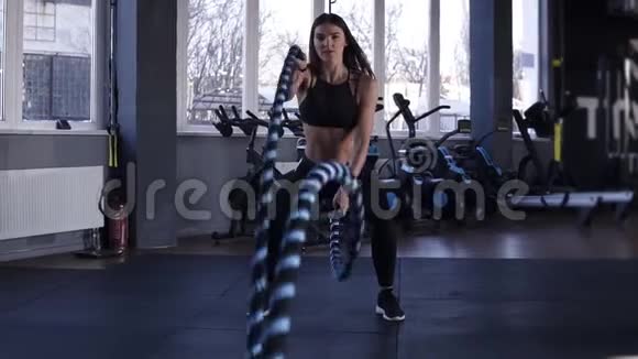 女子在健身房训练用战绳强大迷人的白种人女人在健身房用绳索进行战斗锻炼视频的预览图