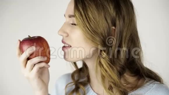 漂亮的头发女人咬着红苹果亲密地调情视频的预览图