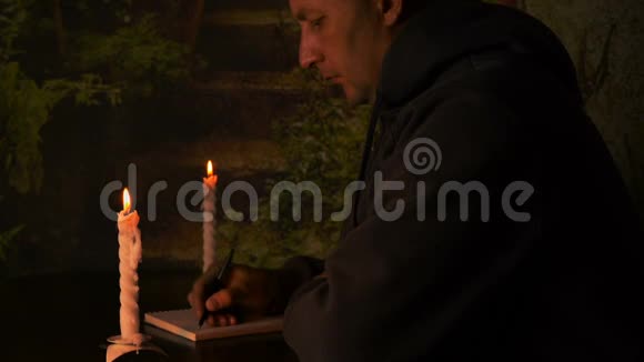 学生晚上用蜡烛做作业学生在黑暗的夜晚用笔在笔记本上写蜡烛视频的预览图