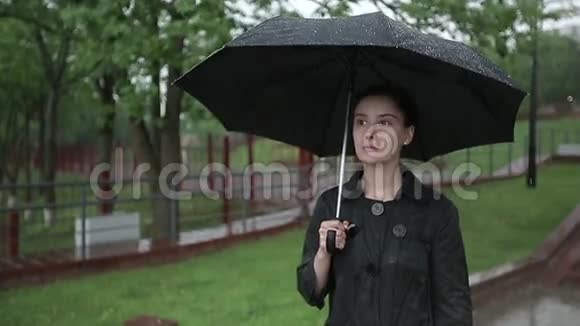 孤独悲伤的女人在大雨中走在街上慢动作视频的预览图