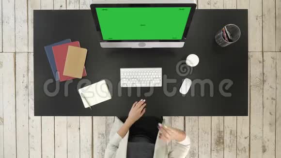 在电脑上做视频会议的人绿色屏幕模拟显示视频的预览图