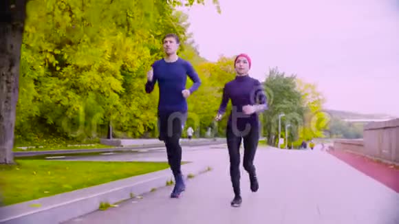 年轻的女人和男人在公园里跑步秋天视频的预览图