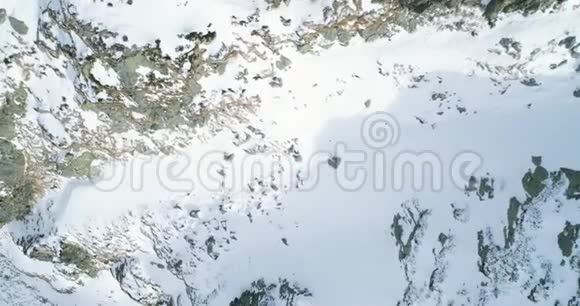 空中俯视冬季雪山岩石落基山脉覆盖着冰雪冰川冬天视频的预览图
