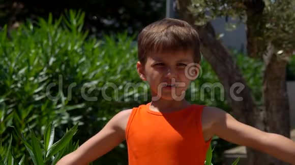 穿着橙色衬衫的男孩展示了肌肉视频的预览图