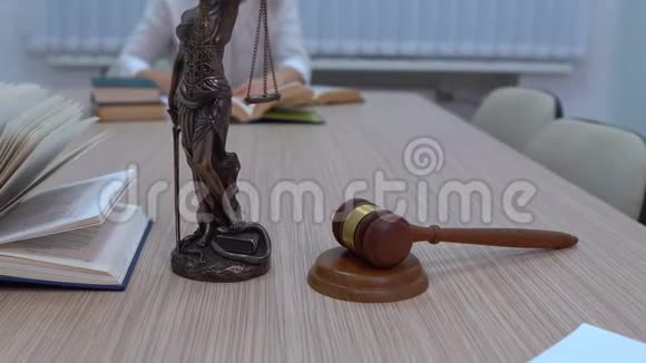 一名律师在工作场所审查文件和立法Themis的小雕像和总计划视频的预览图