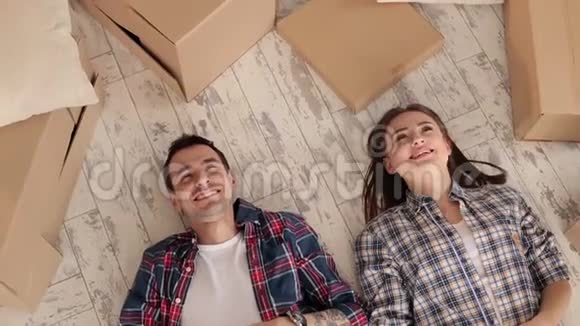 一对幸福的夫妇躺在新公寓的地板上视频的预览图