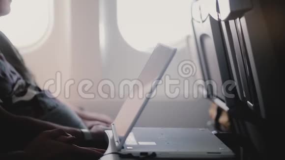 在移动平板视频播放器设备上近距离观看飞机乘客视频的侧面视图使其更接近自己视频的预览图
