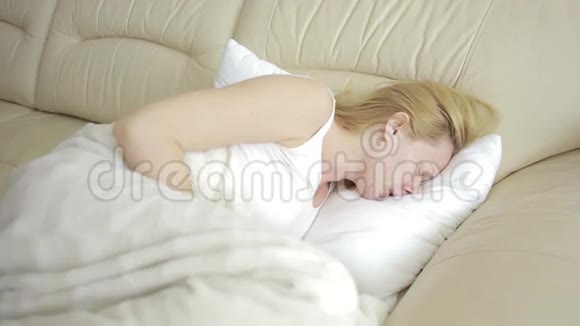 腹痛的女人躺在沙发上女孩喝止痛药视频的预览图