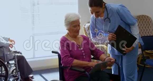 高加索女医生和老年妇女在护理中心讨论数字平板电脑的正面看法视频的预览图
