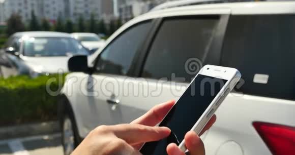 在停车场使用智能手机的女人视频的预览图