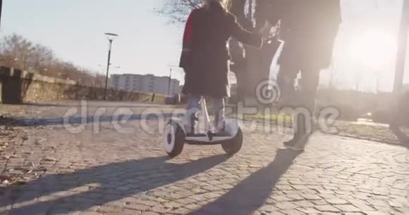 女儿女孩子在城市里和爸爸一起学习Segway骑马现代未来运输技术主动安全视频的预览图