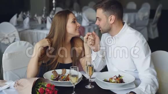 幸福的恋人是在餐厅的浪漫晚餐中牵手交谈和亲吻感情视频的预览图