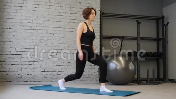 健身白人妇女在健身房做腿部肌肉锻炼的弓步练习活跃的女孩向前走一条腿视频的预览图
