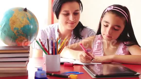母亲和女儿在数码平板电脑上做作业视频的预览图