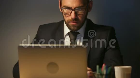 专注体贴的商人在笔记本电脑上工作得很晚紧迫的最后期限任务视频的预览图
