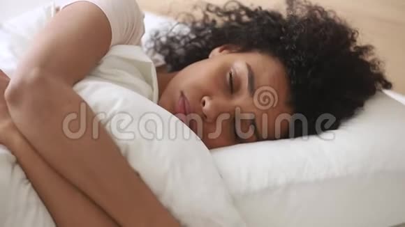 沮丧的非洲女人躺在床上拥抱枕头感到不快乐视频的预览图