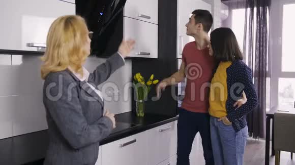 房地产经纪人和夫妇在厨房工作室聊天视频的预览图