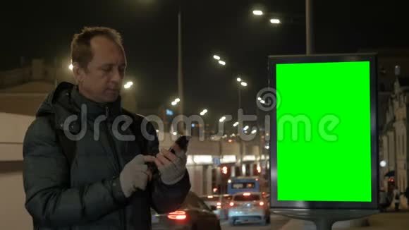 一个男人在城里晚上打电话智能手机是一种交流手段背景情况视频的预览图