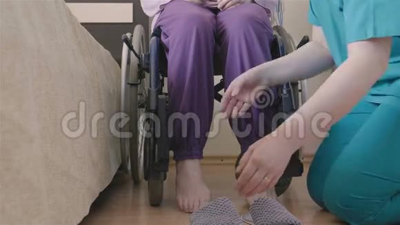 女性照顾者帮助老年妇女穿上鞋子视频的预览图