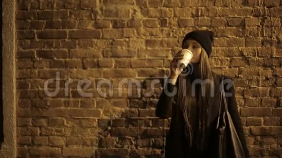 女孩少年晚上在街上喝着咖啡等待视频的预览图