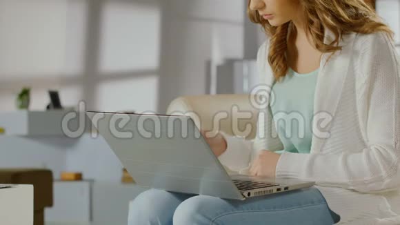 年轻女士用手提电脑卡片核对银行账户余额视频的预览图