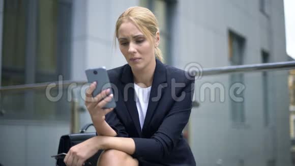 女商人对智能手机中的信息感到不安工作中的烦恼抑郁视频的预览图