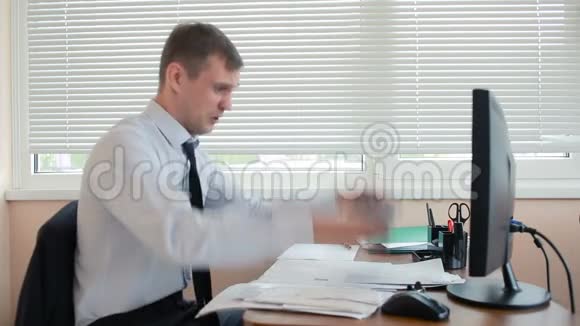 商人愤怒的经理砸了桌子上的键盘坐在办公室里视频的预览图