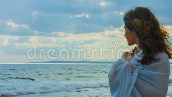 海滩上美丽的年轻女士望着地平线想着爱情浪漫视频的预览图