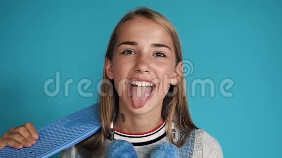 这个十几岁的女孩露出了舌头笑了起来一个年轻漂亮的女人带着雪白的微笑对着视频的预览图