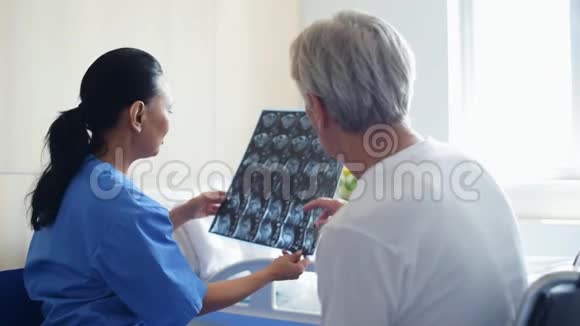 很好的女医生和一个年长的男人讨论x射线扫描视频的预览图