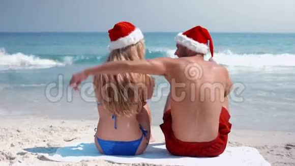 戴上与圣诞老人帽拥抱的情侣观视频的预览图