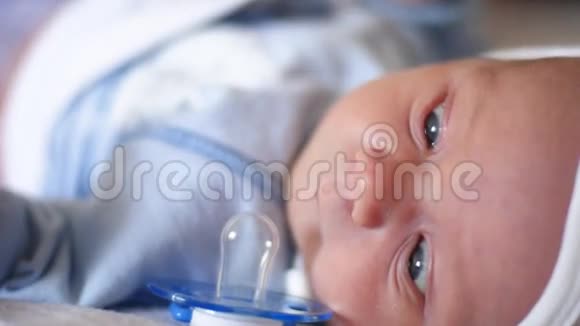 一个可爱的小宝宝正看着相机在一张白色的床单上很开心婴儿环顾四周然后微笑视频的预览图