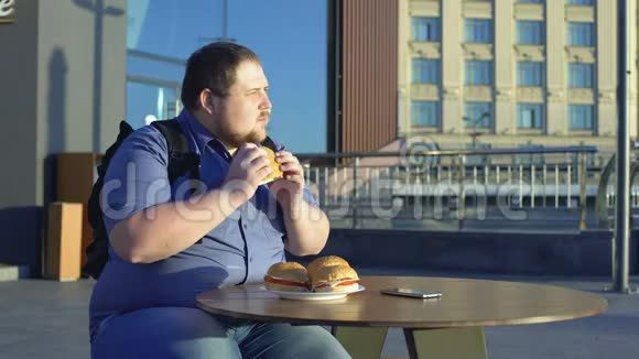 男性上班族在户外吃汉堡吃垃圾食品营养肥胖视频的预览图
