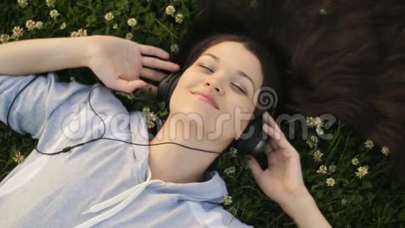 躺在草地上听音乐的女人视频的预览图