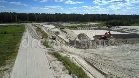 带挖掘机和卡车的采砂场湖鸟瞰视频的预览图