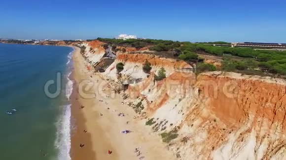 人们在靠近海洋的海滩上放松在悬崖下葡萄牙的空中景色视频的预览图