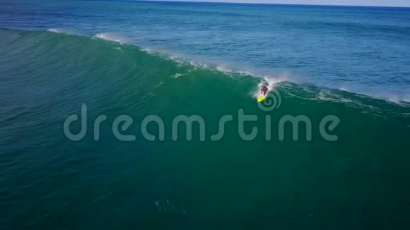 专业冲浪者滑翔在巨大的白色泡沫波中溅在深蓝色绿松石海水中在4k空中海景中视频的预览图