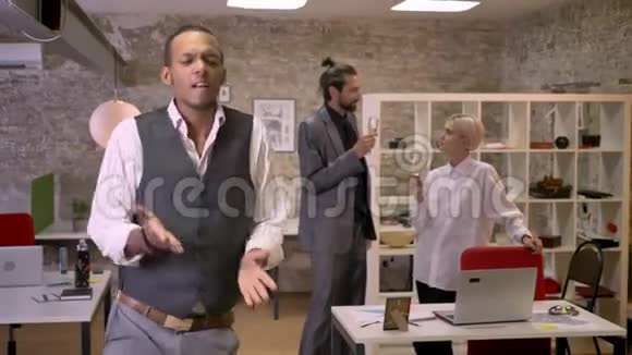 非洲商人在办公室跳舞同事在喝酒聊天放松观念参加公司聚会视频的预览图