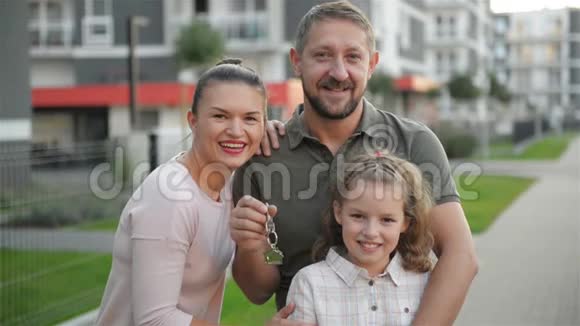 幸福的家庭孩子们站在户外拿着大乡村房子的钥匙微笑豪华房地产业主夫妇视频的预览图