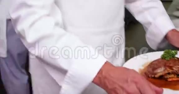 微笑的女服务员被厨师递给一道菜视频的预览图