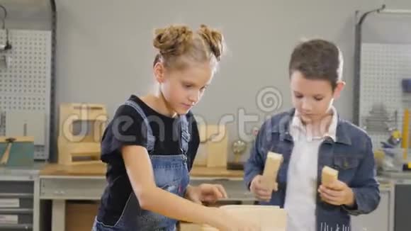 孩子们在工艺车间玩耍可爱的小男孩和他的学龄妹妹玩木制半成品视频的预览图