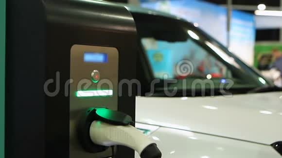 女性测试电子汽车电动汽车展厅自动充电点视频的预览图