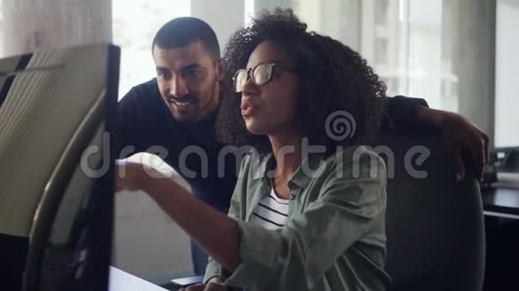 年轻的女商人给她的同事看电脑上的东西视频的预览图