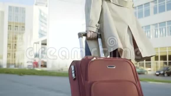 带着行李箱的旅行妇女带着行李在火车站站台上步行前往机场视频的预览图