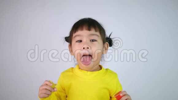 一个快乐微笑的亚洲女孩的肖像享受吃明胶甜点孤立在白色背景视频的预览图